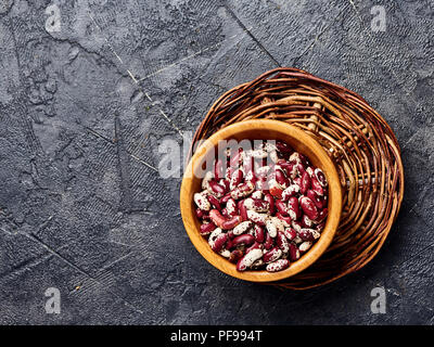 Fagioli rossi con macchie bianche su sfondo nero. Vista dall'alto. Foto Stock