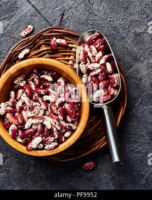 Fagioli rossi con macchie bianche su sfondo nero. Vista dall'alto. Foto Stock