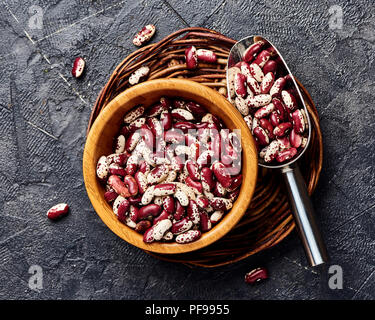 Fagioli rossi con macchie bianche su sfondo nero. Vista dall'alto. Foto Stock