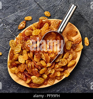 Giallo grande uva passa nera su sfondo di calcestruzzo. Vista dall'alto di uve secche. Foto Stock