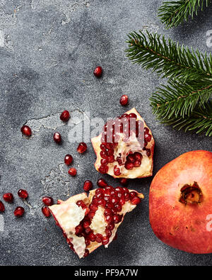 Melograno frutta con semi su sfondo grigio con copia spazio. Vista dall'alto. Foto Stock