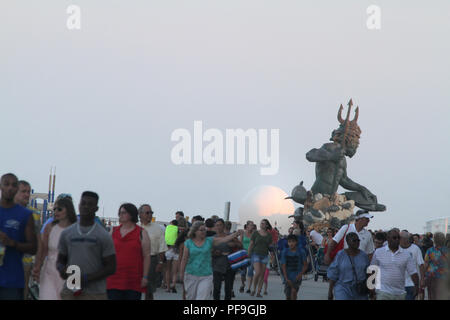 Re Nettuno statua visto in lontananza sul lungomare di Virginia Beach, Stati Uniti d'America. I turisti a piedi sul lungomare. Foto Stock