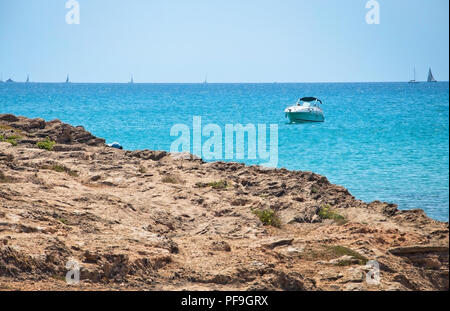 Seascape con rocce e barca su una soleggiata giornata estiva a Mallorca, Spagna. Foto Stock