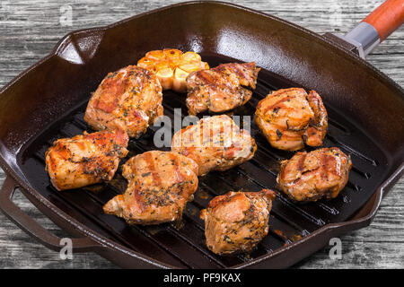 Deliziosa di pezzi di carne alla griglia su una padella su un tavolo rustico, close-up Foto Stock