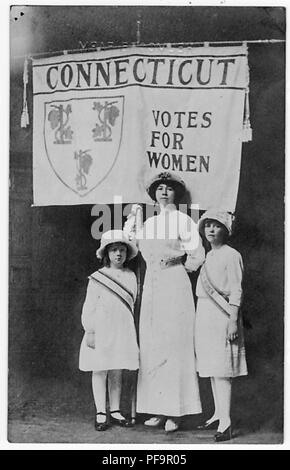 Foto in bianco e nero raffiguranti cartolina Hartford residenti, e gli stati del Connecticut donna Associazione di suffragio, Giuseppina toscane Bennett, tenendo un banner di Connecticut leggere 'voti per le donne, ' fiancheggiata dalle sue figlie, Francesca e Katherine, tutte e tre le indossa di color pallido, Edwardian abiti e cappelli, 1916. () Foto Stock