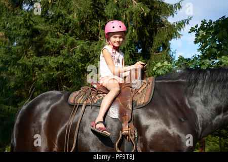 Equitazione, bella equitazione - bambina è in sella ad un cavallo Foto Stock