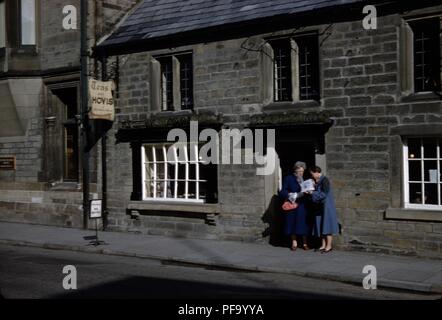 Due turisti femmina di alzarsi e di leggere una mappa al di fuori di una casa da tè con la mitica tè con Hovis ha segno a Londra, Regno Unito, 1955. () Foto Stock