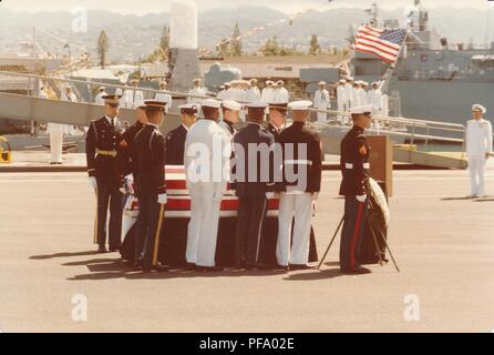 Fotografia a colori che mostra i soldati, inclusi Corpo della Marina degli Stati Uniti (USMC) membri, che circonda una bandiera statunitense-coperto bara, appoggiato su un dock, con ulteriori soldati, un gangplank e la USS Brewton (FF-1086) visibile sullo sfondo, fotografato durante la Guerra del Vietnam, 1970. () Foto Stock