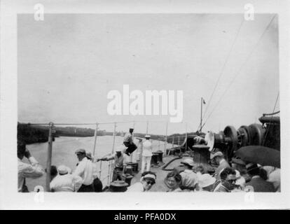 Fotografia in bianco e nero, girato da un angolo alto, che mostra un gruppo di persone, compresi i passeggeri ed equipaggio, a pochi rivolti verso la telecamera, come stanno sul ponte di una nave che naviga il Canale di Panama, con le banche del paese visibile su ogni lato e una serratura nella distanza, 1915. () Foto Stock