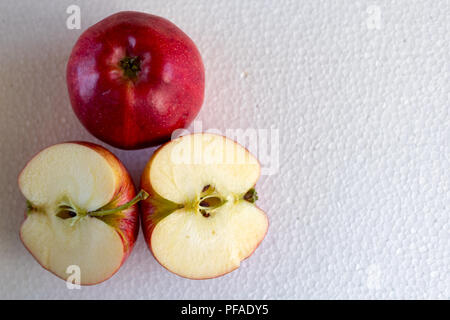 Un isolato red apple e due mezze mele su sfondo bianco Foto Stock