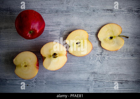 Un isolato red apple e due mezze mele su sfondo bianco Foto Stock
