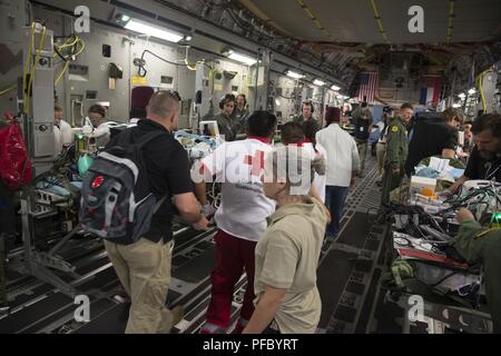 Stati Uniti Esercito il Mag. Julie Rizzo, centro, masterizzare chirurgo e team di piombo da San Antonio militare centro medico in base comune di San Antonio, Texas, dirige il personale durante il caricamento di pazienti su un Air Force C-17 Globemaster III durante una missione umanitaria, Giugno 6, 2018. Il C-17 Globemaser III Equipaggi dal Mississippi Air National Guard's 172nd Airlift Wing, trasportato sei figli dal Guatemala per ricevere cure mediche in Galveston in Texas, bruciature e altri danni subiti durante la recente Fuego eruzione del vulcano, che è iniziato il 3 giugno. Foto Stock