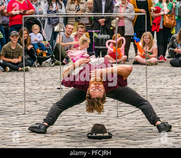 Edinburgh Fringe, Edimburgo, Scozia, Regno Unito. Il 21 agosto 2018. Frequentatori della frangia e musicisti del festival affollano la Vergine denaro sponsorizzato street sede sul Royal Mile nell ultima settimana del Fringe Festival. Un esecutore di strada sul Royal Mile Foto Stock