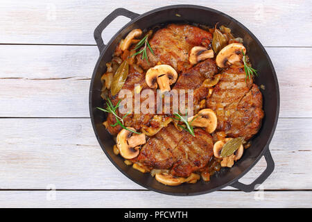 Delizioso filetto di maiale tagliato a fettine, piatti alla griglia e stufati con la cipolla, i funghi, semi di vino bianco secco e spezie in stufato di ferro pan, facile ricetta, vista dal Foto Stock