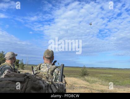 Il lettone il morsetto di giunzione le centraline di attacco guarda una A-10 Thunderbolt II forniscono aria vicino supporto durante lo sciopero di Saber 18 in Adazi, Lettonia il 7 giugno 2018. Diciannove nazioni hanno assistito e partecipato nell'esercizio di costruire in ogni nazione le capacità e migliorare la capacità di partnership. Foto Stock