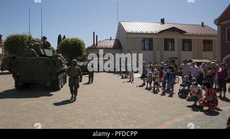 I cittadini di Bauska, Lettonia, guarda come NEGLI STATI UNITI Marines dalla Società Delta, quarta luce ricognizione corazzato battaglione, partono dopo la multinazionale impegno civile cerimonia in Bauska, Lettonia, Giugno 2, 2018 come parte di esercizio Saber Strike 2018. Cittadini provenienti da comunità di Bauska sono incoraggiati ad interagire con gli Stati Uniti Marines e soldati lettone dal lettone Guardia Nazionale 53rd battaglione di fanteria e tour i loro veicoli militari. La quarta LAR Marines condotta una strada marzo dal porto di Klaipeda, Lituania, a consegnare le forniture e le attrezzature per la zona di formazione in Adazai, Lettonia, whi Foto Stock