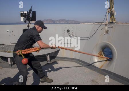 Pireo, Grecia (4 giugno 2018) Boatswain compagno del marinaio reclutare Kale Kisiling, dalla città di Sioux, Iowa, heaves un rimorchiatore linea come il San Antonio-classe di trasporto anfibio dock nave USS New York (LPD 21) arriva al Pireo, in Grecia, per una porta pianificata visitJune 4, 2018. New York, homeported a Mayport, Florida, sta conducendo operazioni navali negli Stati Uniti Sesta flotta area di operazioni a sostegno della sicurezza nazionale USA interesse in Europa e in Africa. Foto Stock