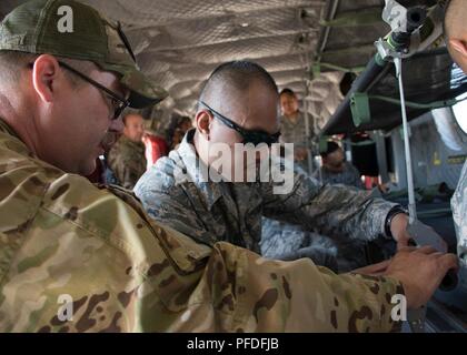 Stati Uniti Esercito personale di riserva Sgt. Justin Gaughan, un tecnico di volo assegnato a 158Reggimento di aviazione dal nuovo secolo centro aria, Kansas, incarica Senior Airman Jeffrey Balino, un odontotecnico assegnato alla 442d Medical Squadron, come bloccare una figliata su lettiera cinghie in un CH-47 elicottero Chinook, Giugno 10, 2018 a Whiteman Air Force Base, Mo. riserva cittadino aviatori praticata cucciolate di fissaggio all'interno dell'elicottero in caso di evacuazione medica. Foto Stock