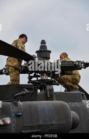 Sgt. Jose Fimbrez (sinistra) e Sgt. Jamie Gil (destra) assegnato alla Task Force Viper° Battaglione, 3° Reggimento di aviazione, XII Combattere la Brigata Aerea condotta di operazioni di manutenzione su un AH-64 Apache elicottero durante lo sciopero di Saber 18 a Bemowo Piskie Area Formazione in Orzysz, Polonia, 11 giugno 2018. Foto Stock