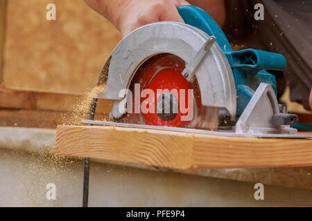 Nuovo home progetto constructiion imprenditore edile lavoratore utilizzando tenuto in mano unità worm sega circolare per il taglio di pannelli Foto Stock