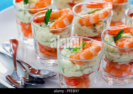 Singoli Cocktail di gamberi bicchierini deliziosa casa con tartara di salsa piccante decorato con foglie di prezzemolo sul piatto bianco sulla tabella MAT per Chri Foto Stock