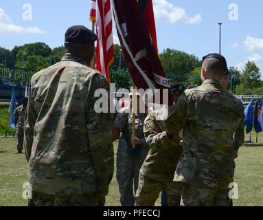 Stati Uniti Army Sgt. Prima Classe Cheryl Mays (centro), Landstuhl Regional Medical Center (LRMC) colore colori di guardia sergente, passa l'ospedale i colori per il comando Sgt. Il Mag. Clark Charpentier (a destra) durante la sua rinuncia di responsabilità cerimonia tenutasi il 30 maggio 2018 a Landstuhl/Germania Foto Stock