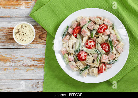 Cetriolo, formaggio, omelette, prosciutto e pomodoro insalata deliziosa cosparsi di pepe macinato fresco e origano essiccato dressing di yogurt con la salsa di senape sulla pl Foto Stock