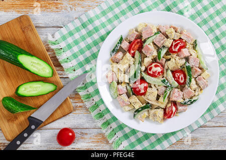 Cetriolo, formaggio, omelette, prosciutto, insalata di pomodoro cosparsi di pepe macinato fresco e origano essiccato sulla piastra. cetriolo tagliato in fetta sul tagliere w Foto Stock