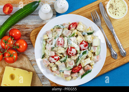 Cetriolo, formaggio, omelette, prosciutto, insalata di pomodoro cosparsi di pepe macinato fresco e origano essiccato sul piatto sul tagliere con yogurt senape sa Foto Stock