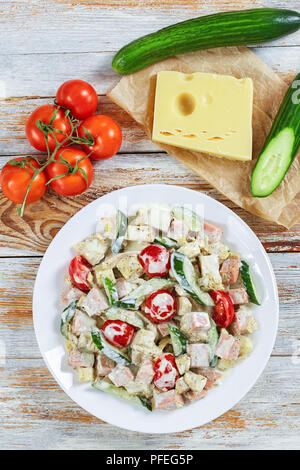 Il cetriolo e formaggio emmenthal, frittata, prosciutto, pomodori deliziosa insalata sana e origano essiccato soffocato in yogurt Salsa mostarda sul piatto da portata. ingredienti o Foto Stock