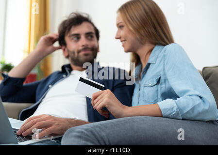 Coppia giovane facendo shopping online in internet e utilizzando una carta di credito Foto Stock