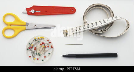 Nastro di misurazione, pennarello, coltello, forbici e spine Foto Stock