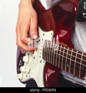 Utilizzando il plettro per suonare la chitarra elettrica, vicino. Foto Stock