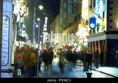 Irlanda, Dublino, Temple Bar, gente camminare lungo la strada di ciottoli rivestiti con bar, night, movimento sfocato Foto Stock