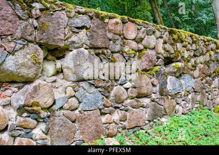 Il vecchio muro di granito nel parco, ricoperti di muschi e licheni. Alatskivi, Estonia, Europa Foto Stock