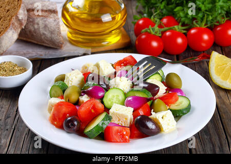 Sani e freschi ortaggi insalata mediterranea con il formaggio feta, cetriolo, pomodoro, olive e cipolla rossa delle lampadine e ingredienti freschi di forno in casa g Foto Stock