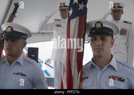 Il ensign nazionale viene presentato durante il guardacoste risoluta il mutamento della cerimonia di comando al settore San Pietroburgo, Florida, 13 giugno 2018. Vice Adm. Scott A. Buschman, Guardia costiera area atlantica Commander, salutando sulla sinistra, ha presieduto la cerimonia in cui Cmdr. Carmen S. DeGeorge, salutando a destra, trasferito il comando della risoluta a Cmdr. Roy R. Brubaker. Foto Stock