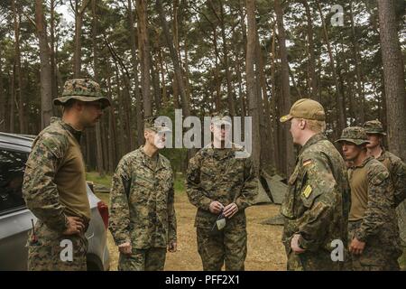 USTKA, Polonia (11 giugno 2018) Lt. Col. Christopher L. Bopp, comandante del battaglione del battaglione di atterraggio (Team BLT), 2° Battaglione, 6° Reggimento Marini, 26 Marine Expeditionary Unit (MEU), il centro sinistra e Sgt. Il Mag. Christopher N. Cary, centro destra, sergente maggiore di BLT 2/6, XXVI MEU, parlare con un tedesco ufficiale della Marina, e i membri del servizio assegnato al battaglione durante una visita in loco per esercitare le operazioni del Baltico (BALTOPS) 2018 in Ustka, Polonia, 11 giugno. BALTOPS è il premier marittima annuale di esercizio focalizzato nella regione del Mar Baltico e uno dei più grandi esercizi in Nord Europa migliorando fl Foto Stock