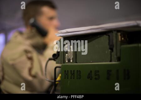 Oklahoma esercito nazionale Guard Capt. Michael Evans, funzionario di collegamento con il quarantacinquesimo campo brigata di artiglieria ( FAB), utilizza una radio SINCGARS per coordinare il supporto di fuoco durante Warfighter 18-5 (WFX) al Camp Atterbury manovra comune centro di formazione, nei pressi di Edimburgo, Indiana, 12 giugno 2018. Evans ha lavorato fuori del mobile Tactical Operations Center per la trentaquattresima divisione di fanteria (ID), Minnesota Guardia Nazionale. WFX 18-5, è a 9 giorno, 24 ore, continua il comando e controllo esercitazione congiunta condotta al treno e prova le forze dell esercito mediante simulazione al calcolatore, focalizzata sulla 34th ID, la sua formazione primaria pubblico Foto Stock