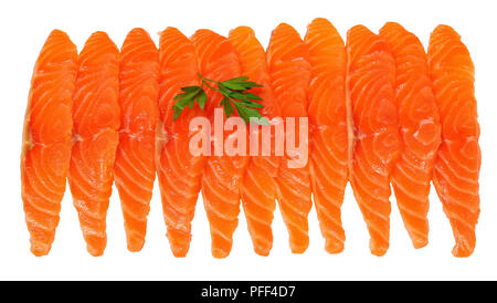 Freschi e deliziosi fette di salmone filetto di pesce con isolati su sfondo bianco con foglie di prezzemolo, close-up Foto Stock