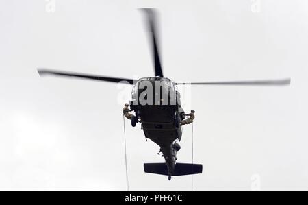 Due Esercito Nazionale soldati di guardia prepararsi a rappel al di fuori di un esercito di Oregon Guardia Nazionale HH-60M Black Hawk elicottero durante il comando di aeromobili e la porzione di controllo del Rappel Master su Giugno 13, 2018 a Camp Rilea vicino al Warrenton, Oregon. I soldati devono inviare con successo due rappelling soldati da aeromobili a quasi 90-piedi sopra il terreno e il punteggio al cento per cento al fine di superare il test. ( Foto Stock