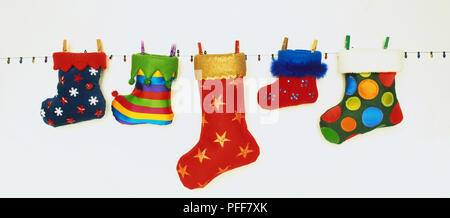 Assortimento di coloratissimi calze di Natale appeso sulla linea di lavaggio, close up Foto Stock