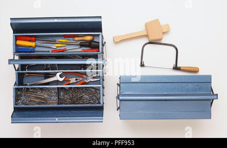Chiuso toolbox, Mallet, seghetto, aprire la Casella degli strumenti contenente i cacciaviti, chiavi, chiodi e pinze, vista da sopra Foto Stock