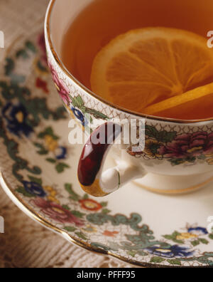 Il tè serviti in un disegno di fiori cina cup, guarnito con una fettina di limone, vicino ad alto angolo di visione Foto Stock