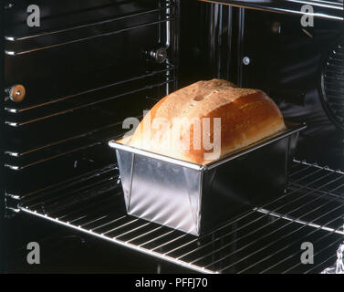 Filone di pane all'interno di un forno. L'impasto di zuccheri naturali caramellare per dare una crosta dorata. Foto Stock