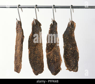 Curate biltong appesi da ganci di carne Foto Stock