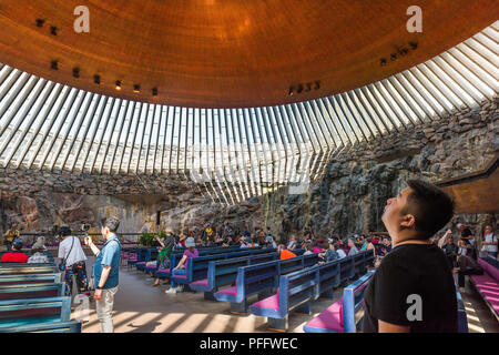 Helsinki Chiesa Temppeliaukio, un turista all'interno del Temppeliaukion Kirkko o 'Rock Chiesa' nel centro di Helsinki guarda il suo enorme tetto in rame, Finlandia. Foto Stock