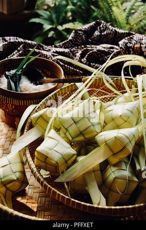 Ketupat, la tradizionale a forma di diamante la torta di riso in involucro di tessuto di foglie di noce di cocco; altamente popolari durante le celebrazioni Eid. Foto Stock