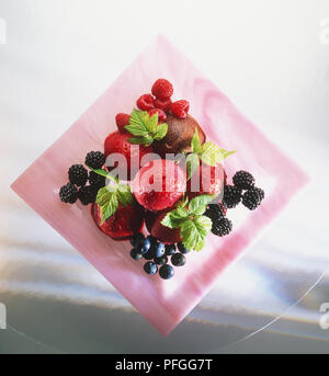 Il sorbetto alla frutta, servito con frutta fresca inclusa lamponi, more di rovo e ribes nero e guarnite con foglie di menta, vista da sopra Foto Stock