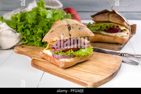 Sandwich italiano sulla ciabatta con prosciutto, mozzarella, pomodoro e insalata romaine Foto Stock